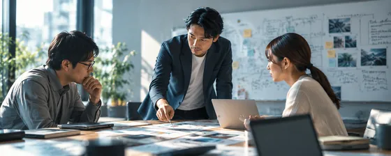 ホワイトボードの前で、資料を見ながら話し合う三人