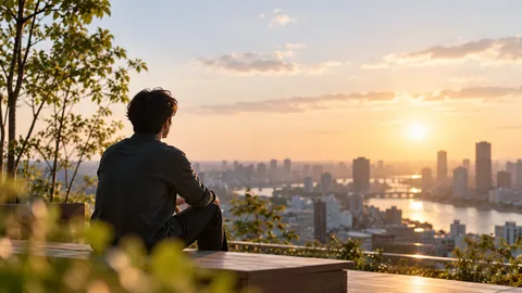 夕暮れの街をひとりで眺めている人の後ろ姿